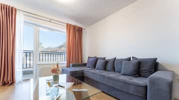 Departamento Deluxe, 1 habitación, balcón, vista a la montaña | Área de sala de estar | Smart TV de 125 cm con canales por cable y Netflix