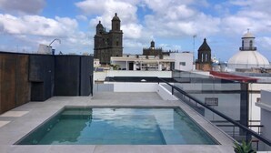 A rooftop pool with a view of historical buildings in the background.