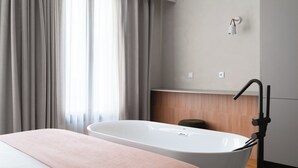 Une salle de bain moderne avec une baignoire sur pieds, un lavabo et un porte-serviettes.