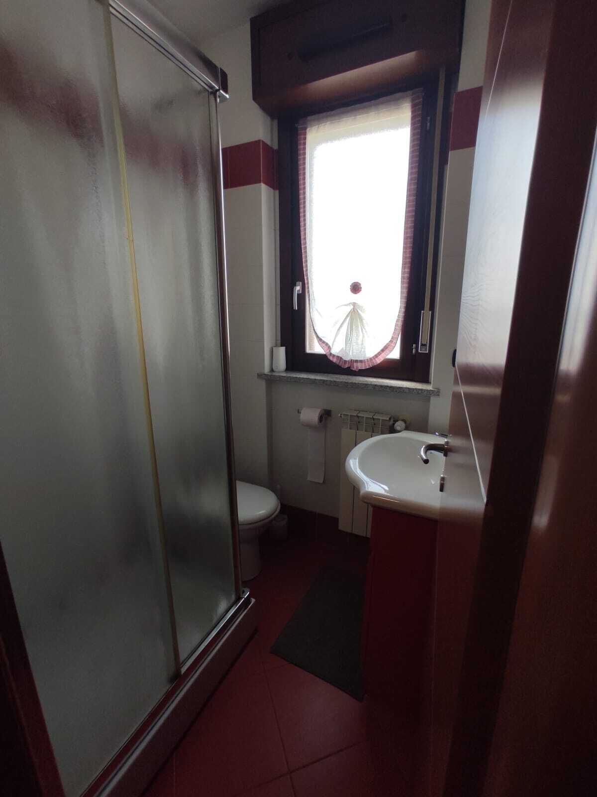 A bathroom with a shower, toilet, and sink.