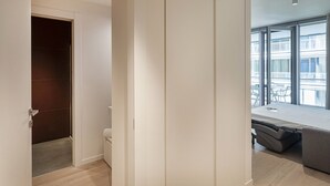 Une chambre à coucher moderne avec une grande fenêtre, un lit et une armoire.