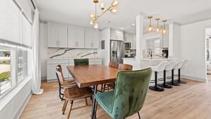 A modern kitchen with white cabinets, a marble countertop, and stainless steel appliances. - Stylish Villa Near Treasure Island Beaches (Treasure Island)