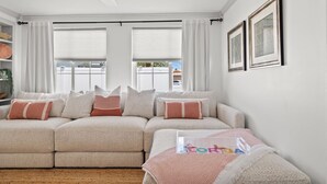 A living room with a beige sectional sofa, a coffee table, and a ceiling fan. - Stylish Villa Near Treasure Island Beaches (Treasure Island)
