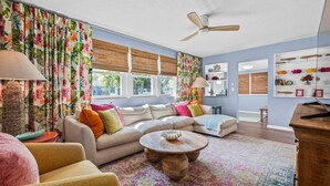 A living room with a sectional sofa, a round coffee table, and a ceiling fan.