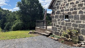 A stone building with a wooden deck, a metal railing, and a small window with the number 5. - The House of Small Things (Lascelle)