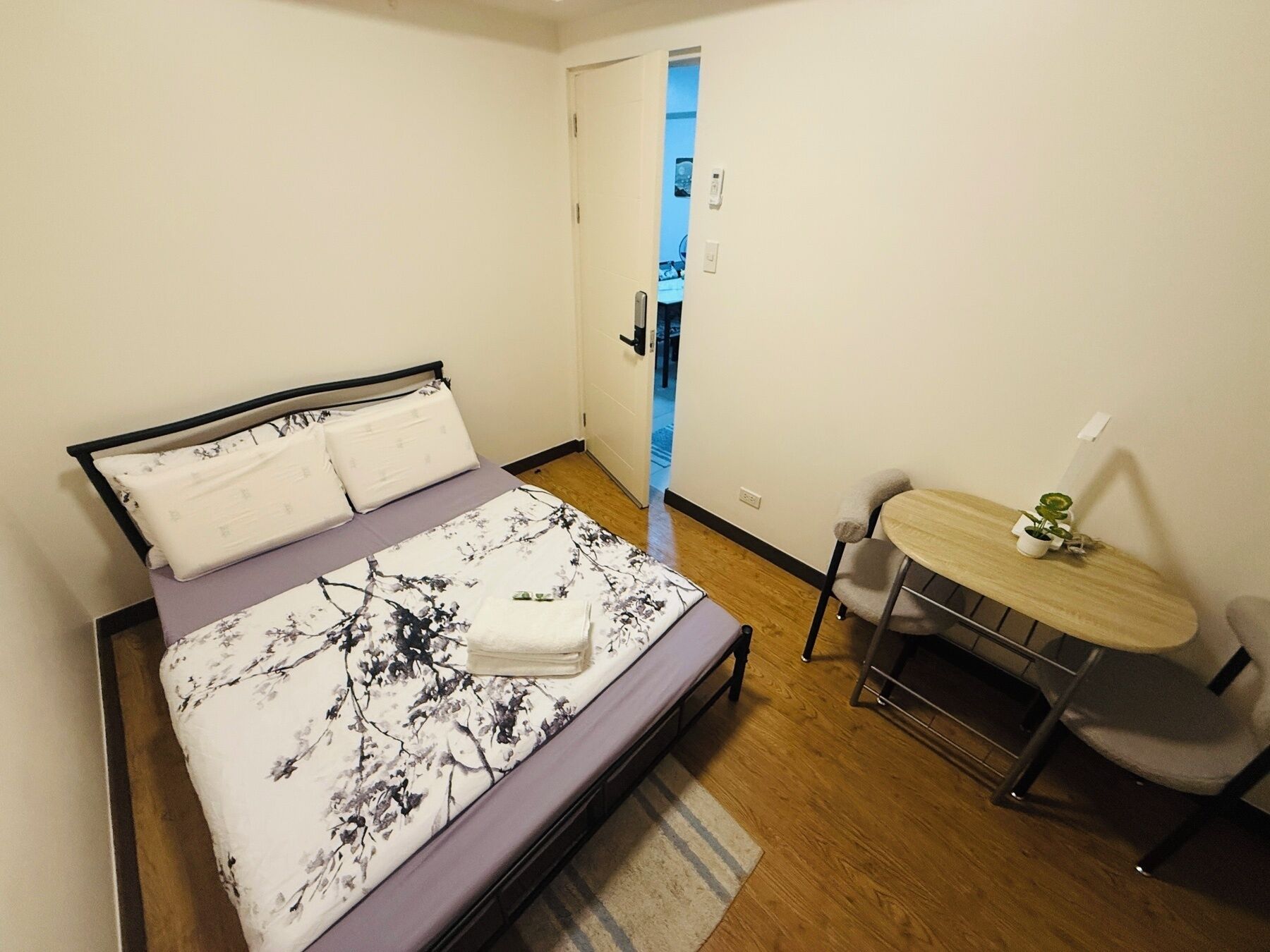 Een slaapkamer met een bed, een klein tafeltje en een stoel.