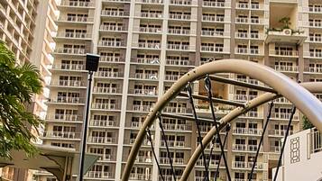 Un edificio de gran altura con múltiples balcones y un columpio en primer plano.