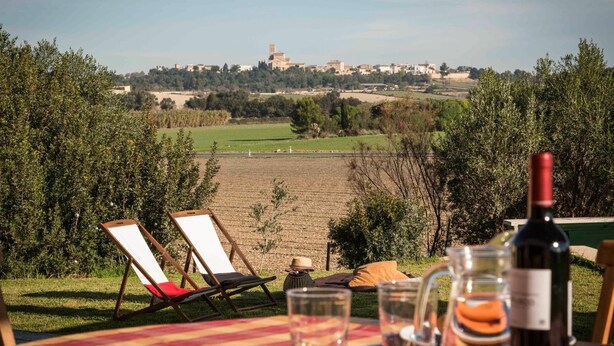 A table set outdoors with a view of a rural landscape, including fields and distant buildings. - Villa Baix des Pujol: Modern Luxury & Relaxation in Mallorca (Petra)