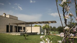 A modern house with a patio, a small garden, and blooming trees. - Villa Baix des Pujol: Modern Luxury & Relaxation in Mallorca (Petra)