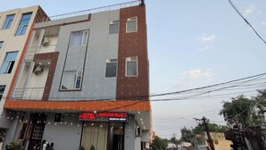 Un hotel de varios pisos con fachada moderna, que presenta una entrada destacada con un letrero que dice "HOTEL LAKMAKTHAR PALACE".