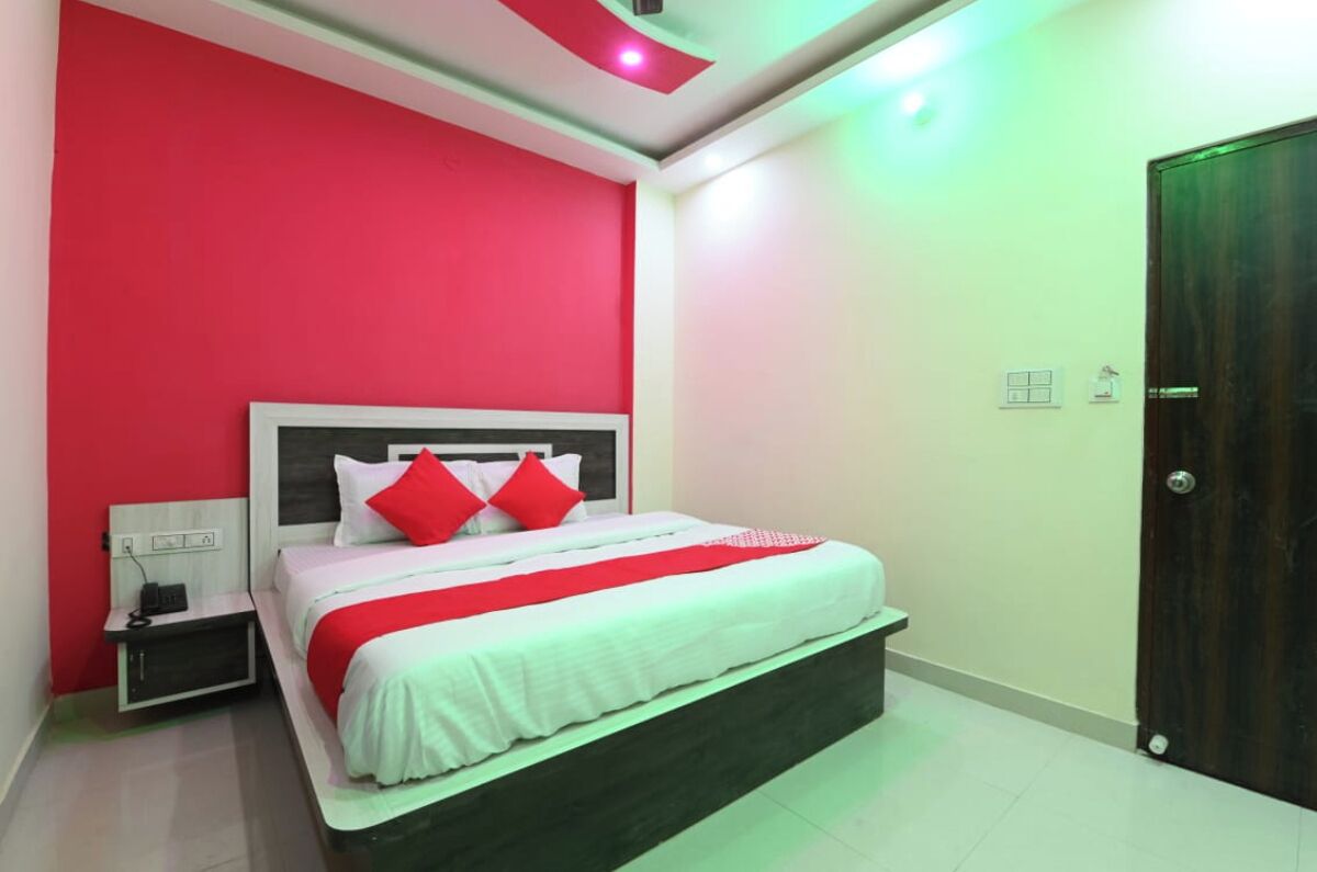Un dormitorio con cama, mesita de noche y una puerta.