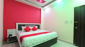 Un dormitorio con cama, mesita de noche y una puerta.