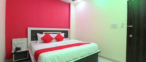 Un dormitorio con cama, mesita de noche y una puerta.