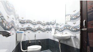 Baño con inodoro, lavamanos y azulejos decorativos.