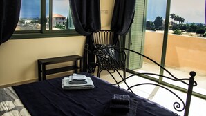 A room with a bed, a chair, and a view of the outside. - BELLEVUE VILLA. Completely private 3-bedroom villa with pool, gardens & orchard. (Anarita)