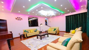 A modern living room with two sofas, a coffee table, and a TV. - Spacious & Beautiful 5-bedroom Villa in Nairobi with WiFi (Nairobi)