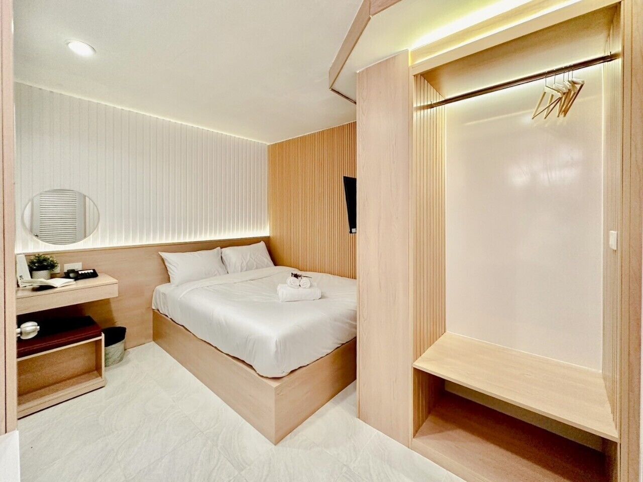A modern bedroom with a bed, bedside table, and a built-in wardrobe.