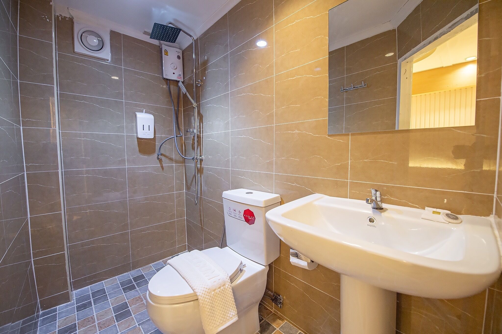 Un baño con inodoro, lavabo y ducha.