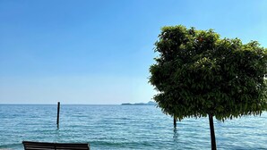 A bench by a calm sea with a clear sky.