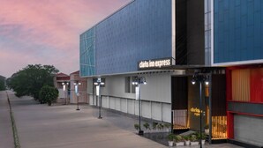 Un bâtiment moderne, orné d’une enseigne « Clarks Inn Express », avec une grande façade vitrée et une entrée rouge.