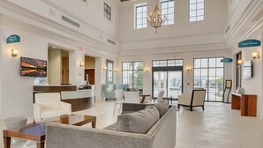 A spacious lobby with a reception desk, seating area, and a Game Room sign.