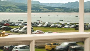 Un estacionamiento con coches y vistas a un lago y montañas.