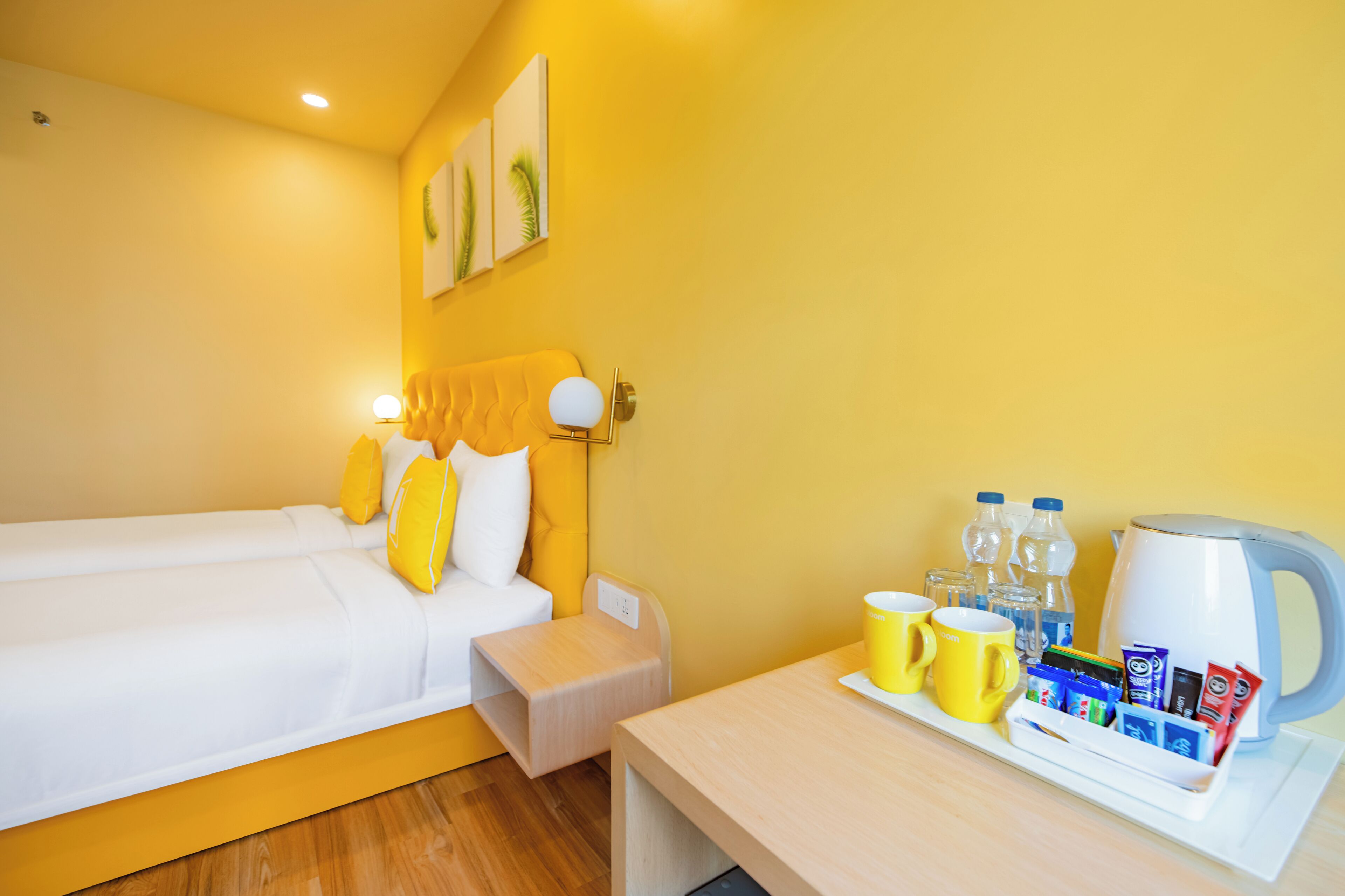 A hotel room with a bed, bedside table, and a tray table with breakfast items.