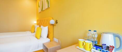 A hotel room with a bed, bedside table, and a tray table with breakfast items.