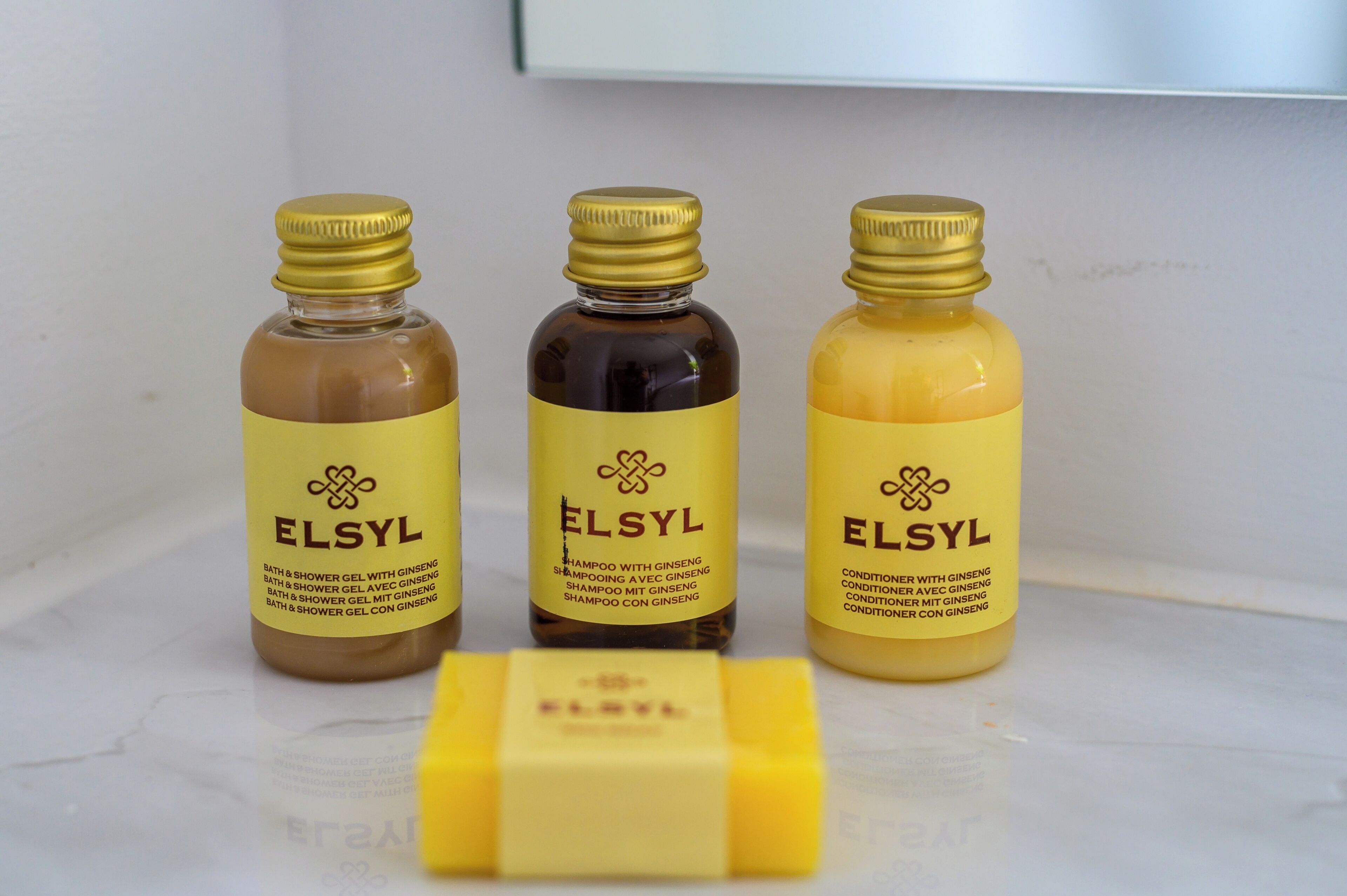 Tres botellas de gel de baño y ducha ELSYL con ginseng, y una pastilla de jabón.