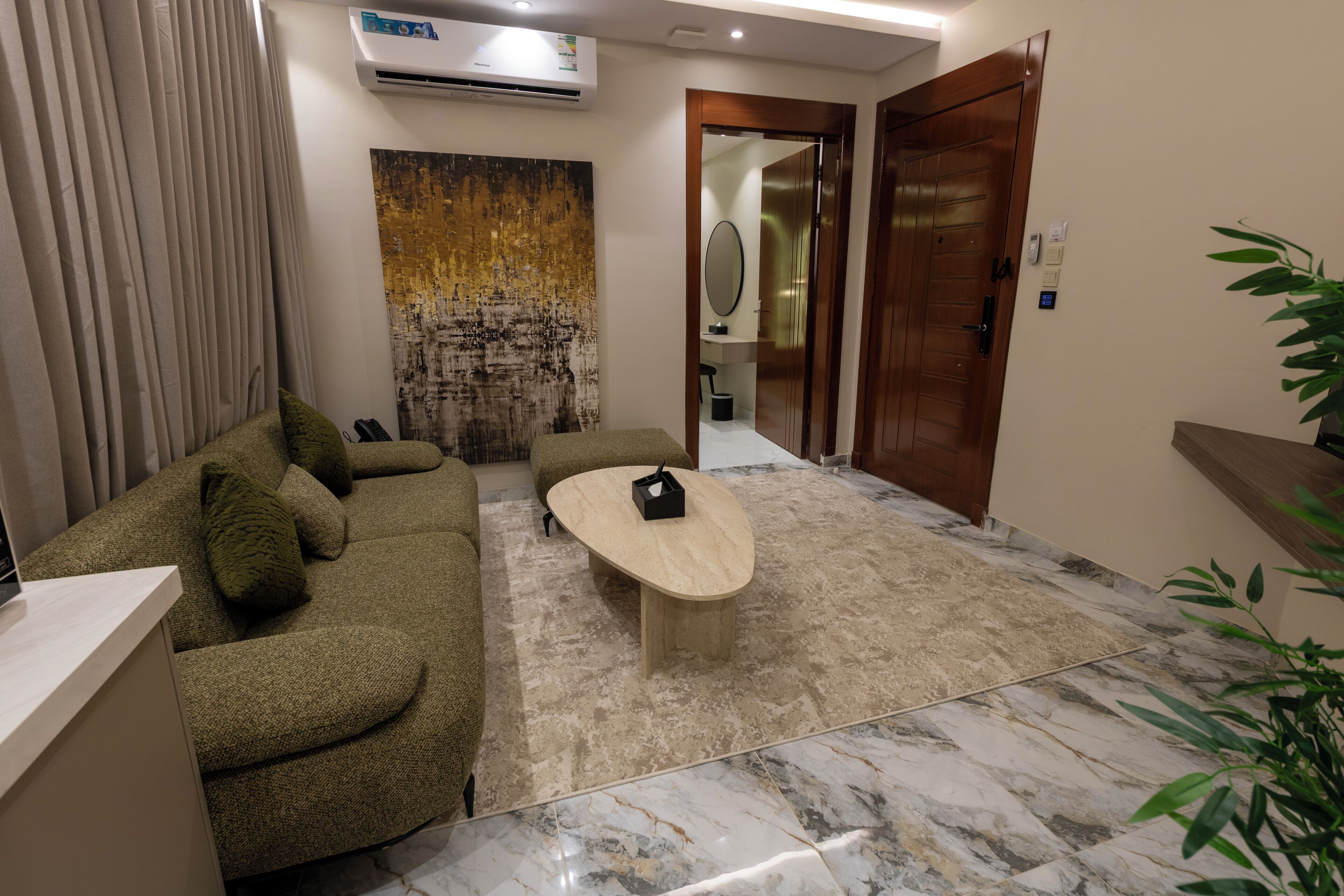 A modern living room with a sofa, a coffee table, and a large abstract painting.