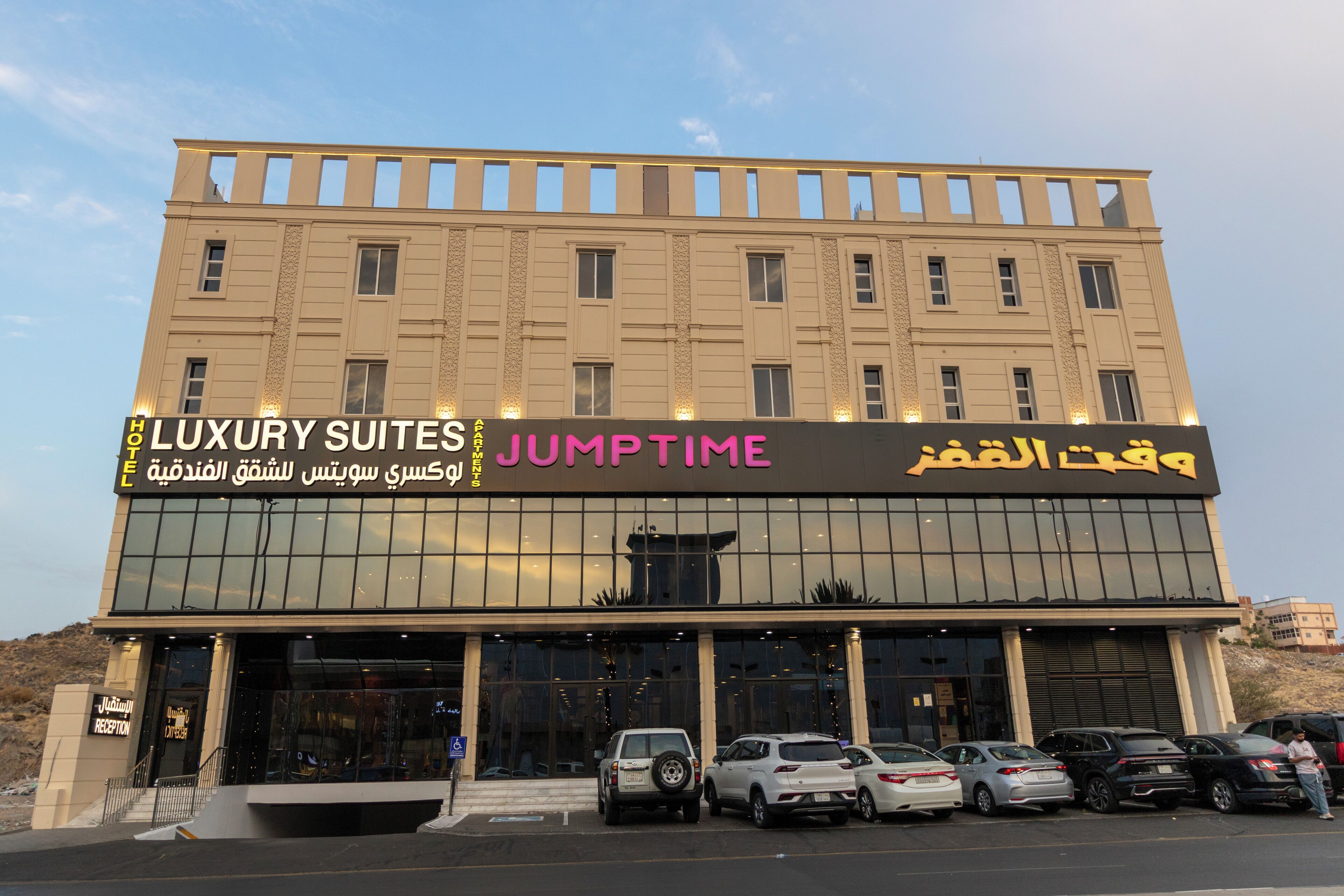 Um hotel com uma placa indicando 'LUXURY SUITES' e 'JUMPTIME' em vários idiomas.