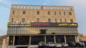 Um hotel com uma placa indicando 'LUXURY SUITES' e 'JUMPTIME' em vários idiomas.
