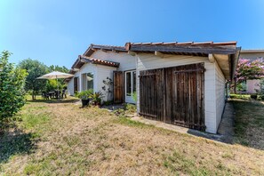 A house with a patio, a wooden fence, and a garden.