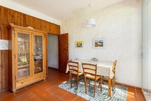Un coin repas comprenant un buffet en bois, une table avec des chaises et un tapis à motifs.