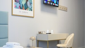 A hotel room with a bed, a desk, a chair, a television, and a framed artwork on the wall. - Moon ApartHotel (Wrocław)
