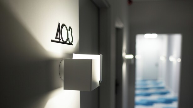 A hallway with a number sign '403' and a light fixture. - Moon ApartHotel (Wrocław)