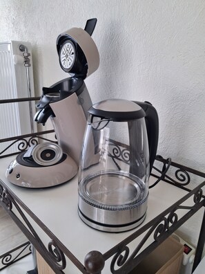 Une machine à café et une verseuse en verre sur une table en métal.