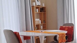 Un moderno comedor con una mesa redonda, dos sillas y una estantería al fondo.