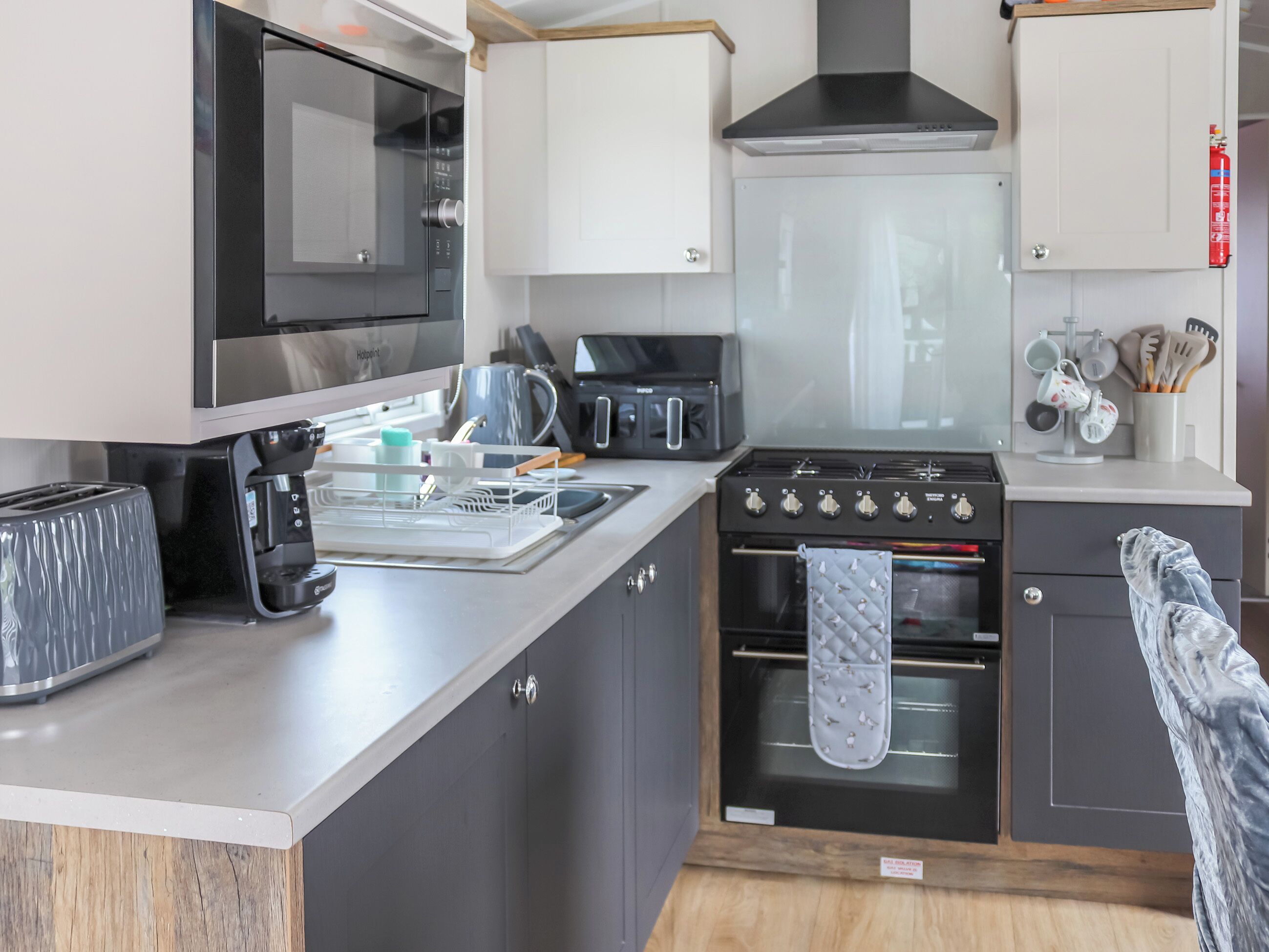A modern kitchen with a built-in microwave, toaster, coffee maker, and oven.