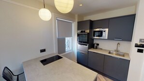 A modern kitchen with a built-in oven, microwave, and stainless steel sink. - 2 Mins to Cathedral | Georgian Quarter | City Break (Liverpool City Centre)