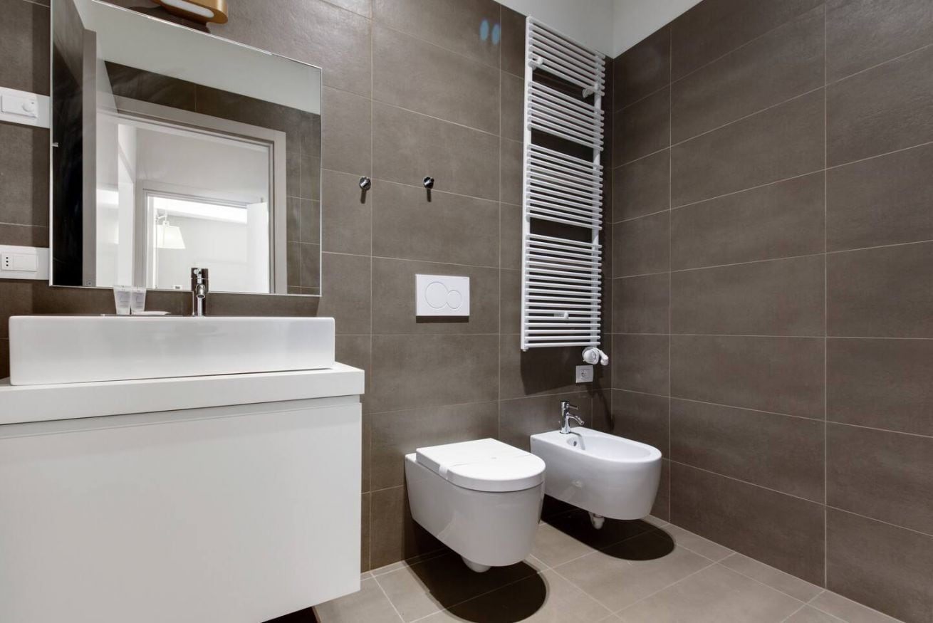 Un baño moderno con un lavabo blanco, un bidé y una bañera.