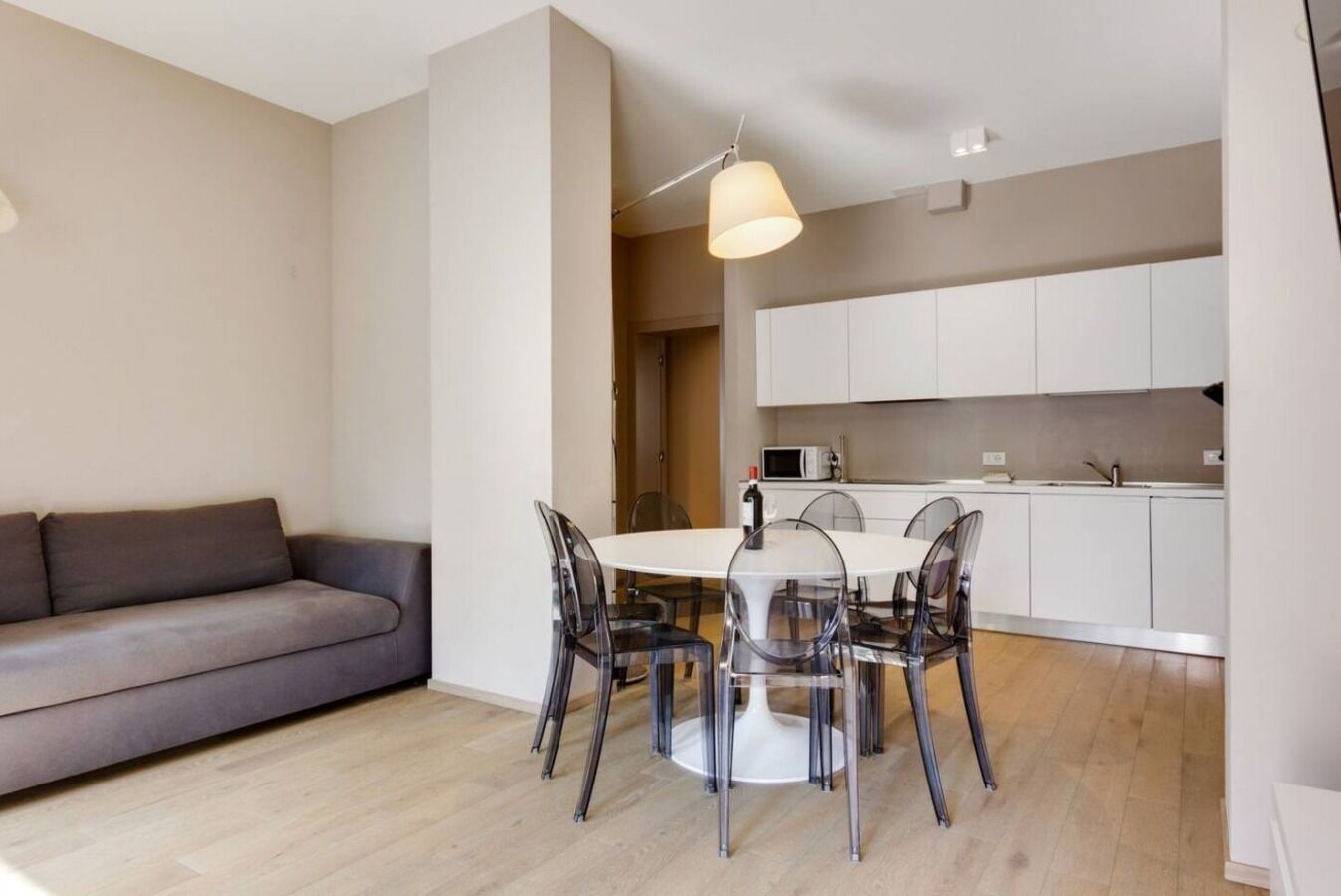 Un espacio de estar moderno con comedor, sofá y cocina.