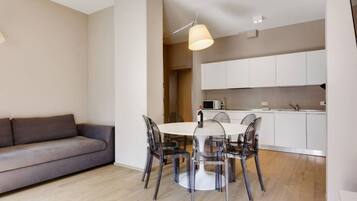 Un espacio de estar moderno con comedor, sofá y cocina.