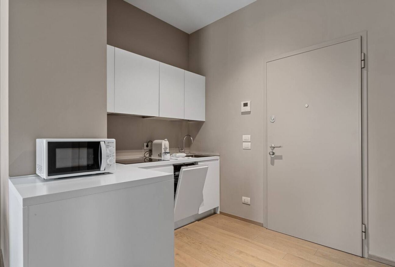 A compact kitchen with a microwave, a coffee maker, and a dishwasher.