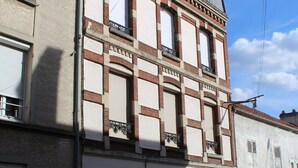 A multi-story building with a classic architectural style, featuring a balcony on the second floor and a garage entrance at the ground level. - Apartment for 2 people in the heart of downtown Epernay- Champagne, (Epernay)