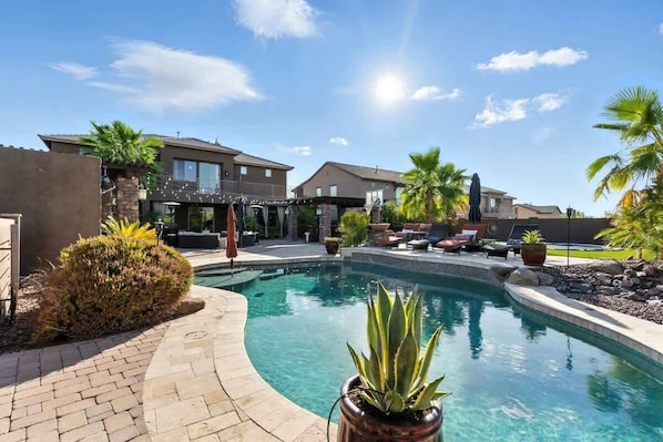 A residential area with a swimming pool, houses, and outdoor seating.