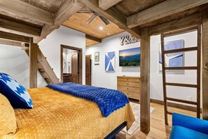 A bedroom with a bed, a dresser, a mirror, and a painting on the wall.