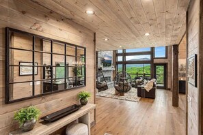 A spacious room with a large wooden wall, a hanging chair, and a view of the outdoors.