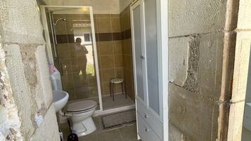 Een douche, handdoeken, zeep, shampoo