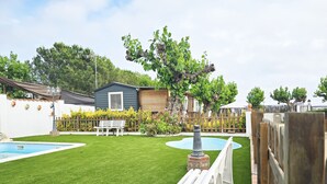 A backyard with a swimming pool, a wooden deck, and a small shed.